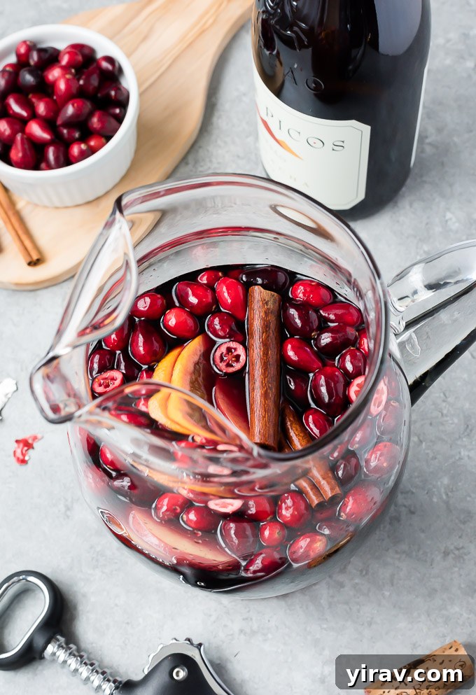 A large pitcher filled with vibrant cranberry sangria, ready to be served
