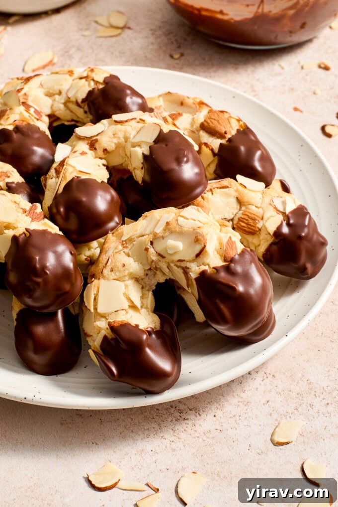 Finished chocolate dipped almond horn cookies arranged on a serving plate.
