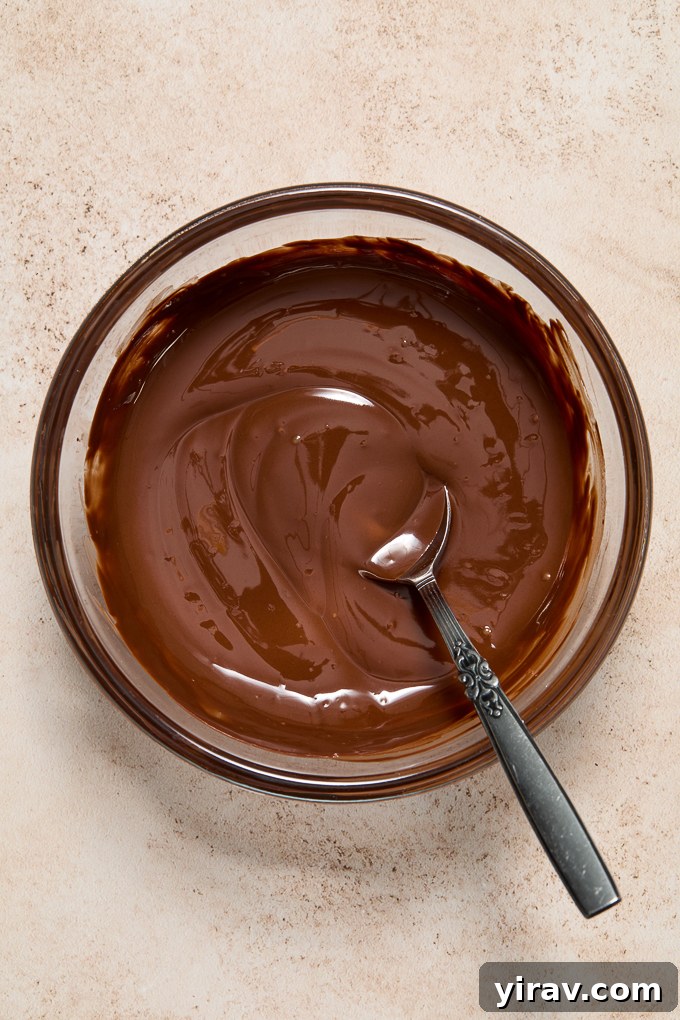 Bowl of smooth, melted chocolate for dipping almond horn cookies.
