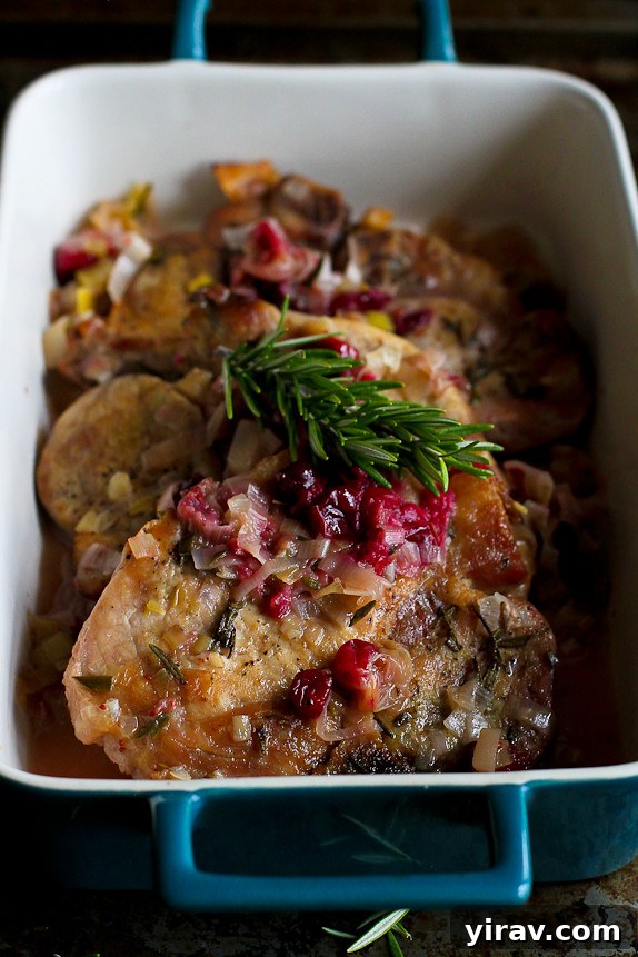 A blue baking dish holds tender slow cooker pork chops with cranberries.