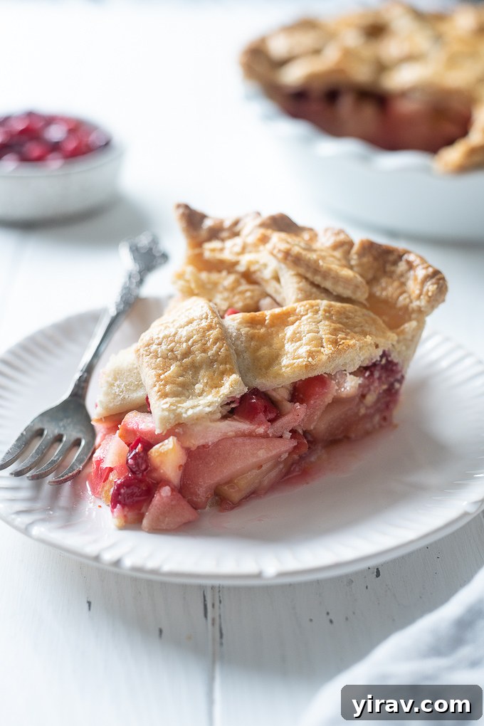A generous slice of apple cranberry pie, ready to be enjoyed on a plate.