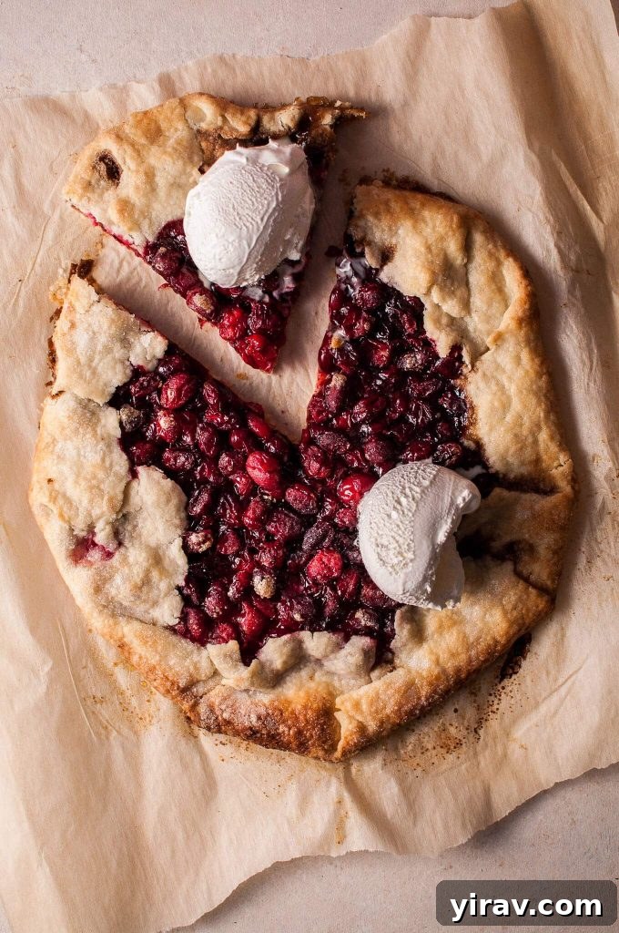 An overhead shot of a rustic cranberry galette with one slice gently pulled away.