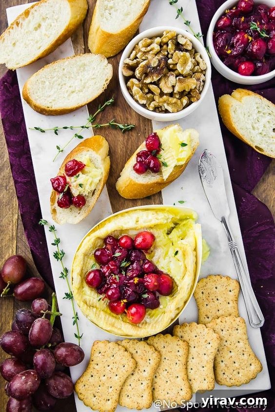 An overhead shot of warm, baked Camembert cheese on a white platter, ready to be served.