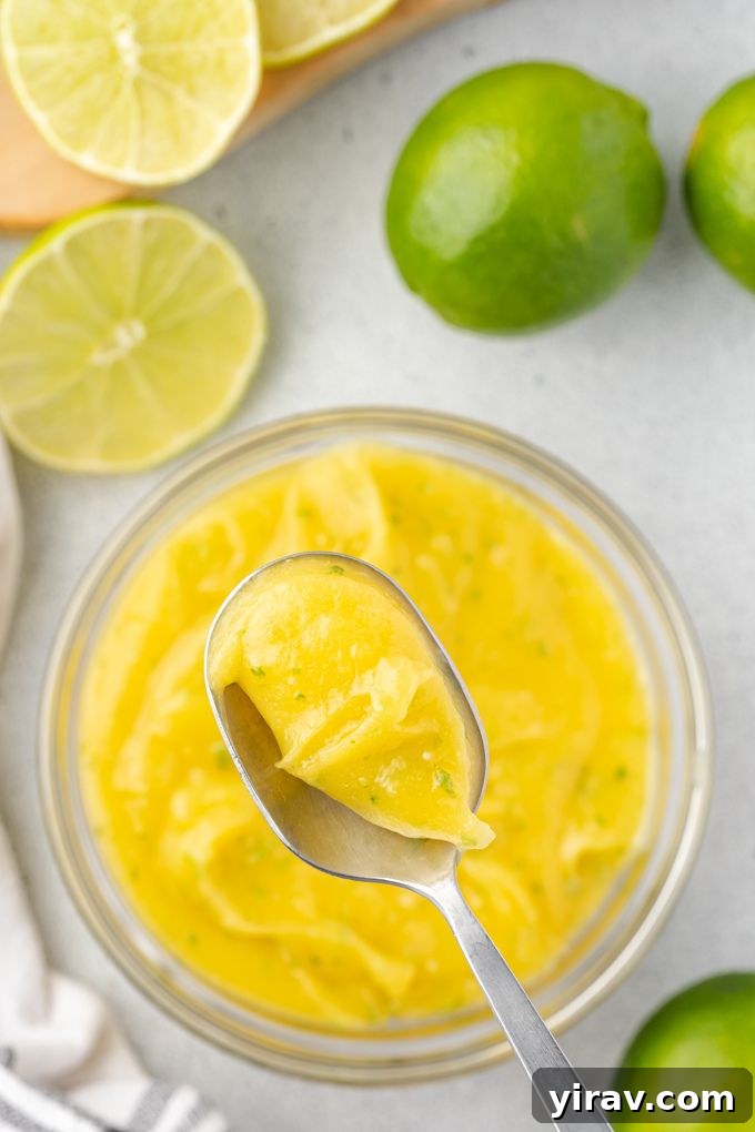 A spoonful of vibrant lime curd, highlighting its creamy and smooth texture.