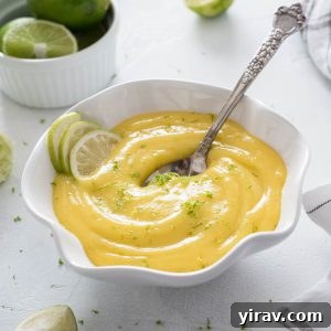 Bowl of lime curd with spoon buried in the middle