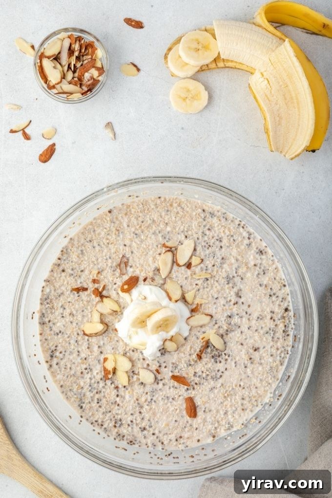 Mixing bowl of steel cut overnight oats with banana and almonds