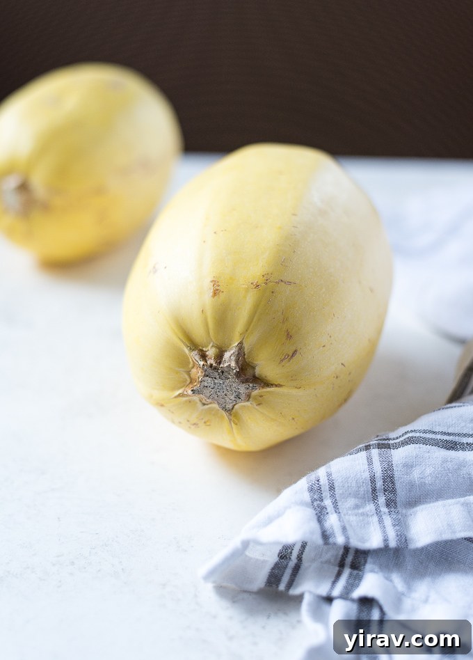 Whole spaghetti squash laying on its side on a wooden surface