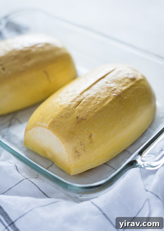 Halved spaghetti squash in a glass baking dish, ready for microwaving