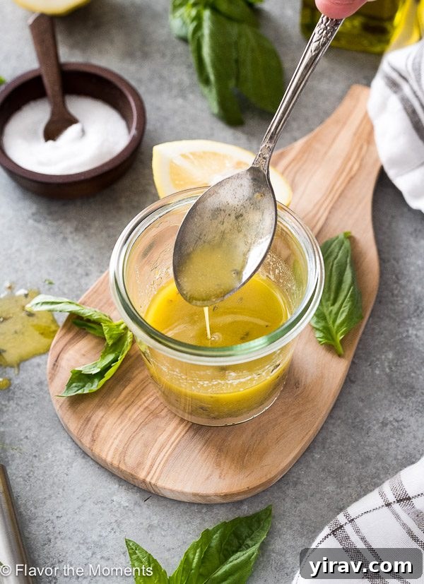 Zesty Italian dressing drizzling from spoon into jar