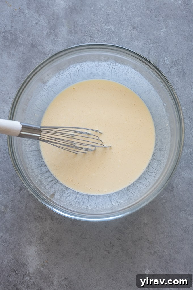 Wet ingredients in mixing bowl for oat flour Greek yogurt pancakes.