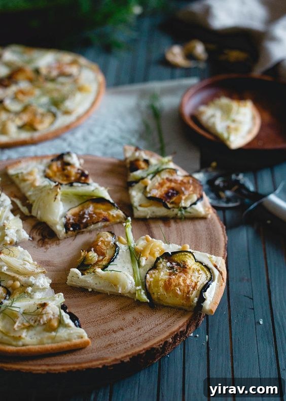 A rustic wood serving board featuring a roasted eggplant fennel pizza with creamy white topping.