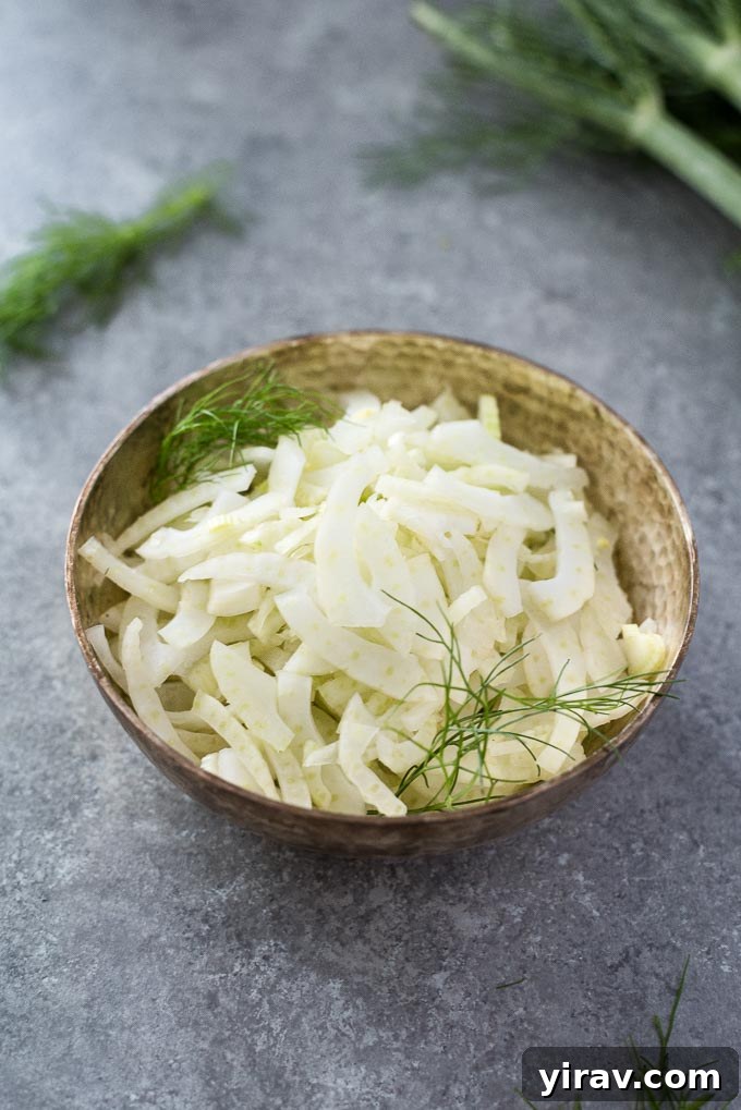 A bowl filled with freshly sliced fennel, showcasing its crisp texture and readiness for use in various recipes.