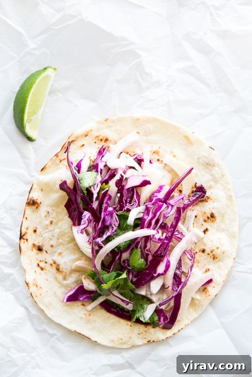 An overhead view of a delicious spicy fish taco topped with a fresh fennel slaw.