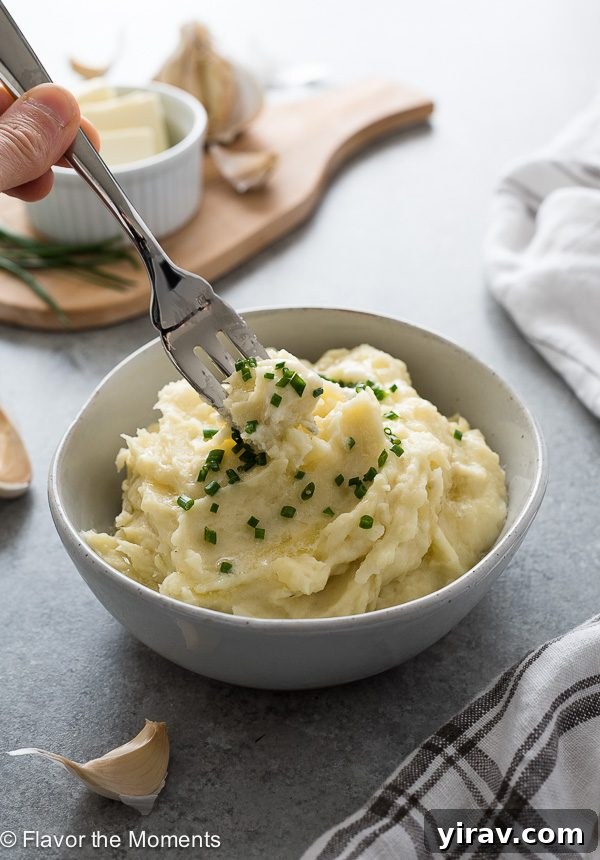 Quick and Creamy Instant Pot Mashed Potatoes 7 A fork buried in the center of a serving of fluffy Instant Pot mashed potatoes, demonstrating their perfect texture.