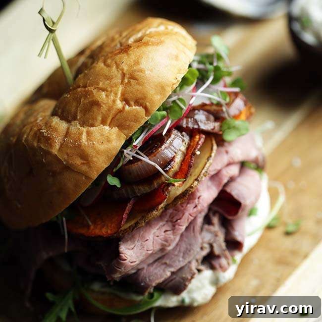 A loaded roast beef sandwich with a toothpick in the top, hearty and flavorful.