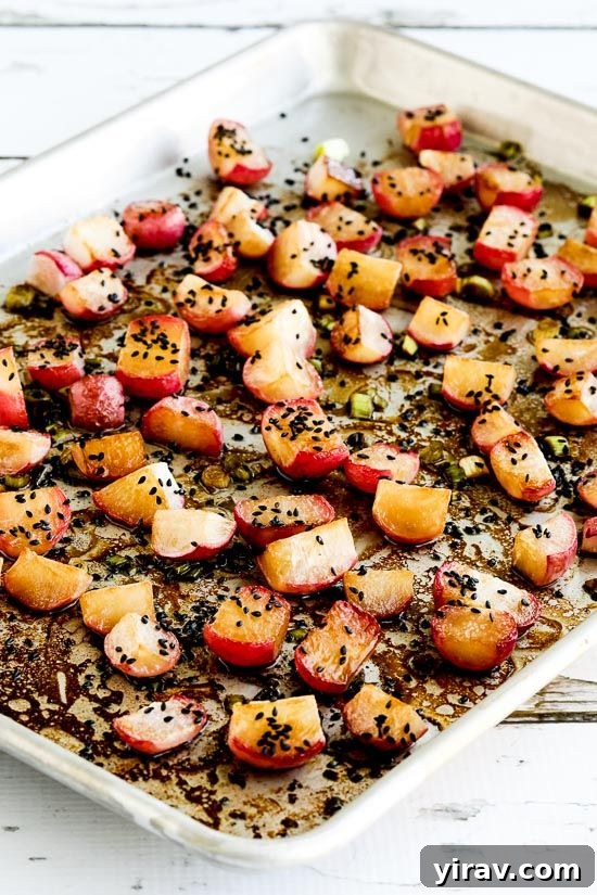 Roasted radishes with sesame seeds on a baking sheet, a flavorful and healthy side.