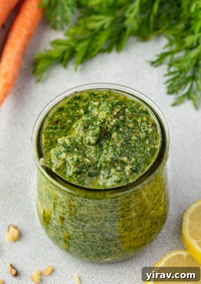Vibrant Carrot Greens Pesto 2 Vibrant green Carrot Top Pesto in a glass jar, showcasing its fresh and inviting texture.