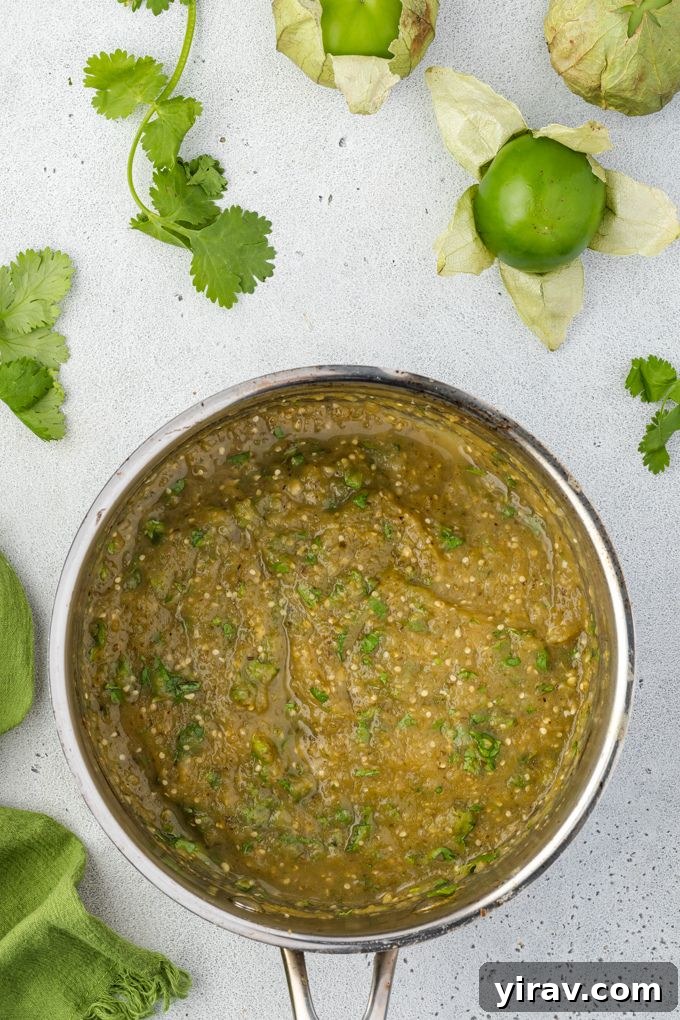 Green enchilada sauce in pan with cilantro on top