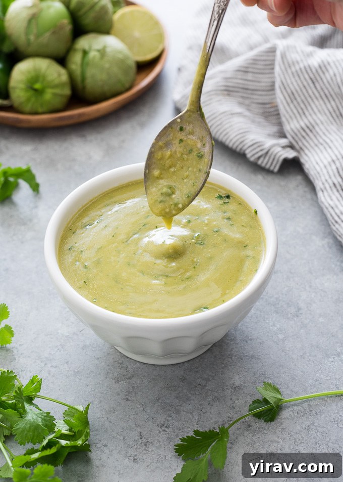 Green enchilada sauce drizzling into a bowl
