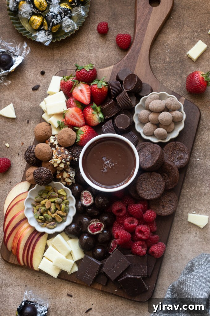 A grand chocolate charcuterie board overflowing with an irresistible assortment of truffles, candies, fresh berries, and diverse chocolates, presented beautifully for a festive occasion.