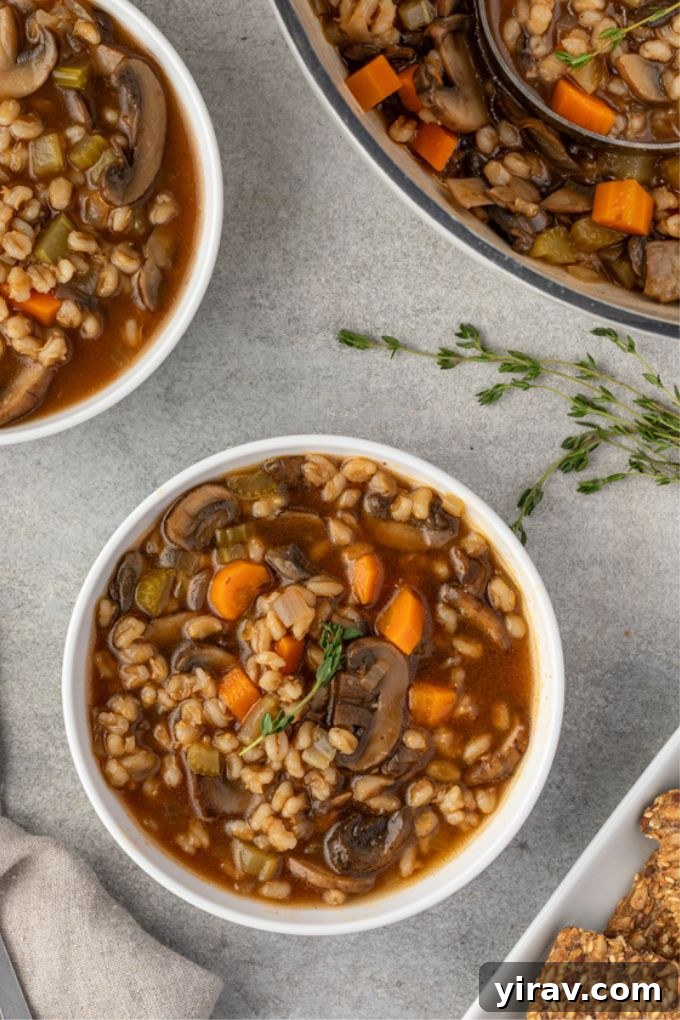 Mushroom and barley soup in a bowl with thyme garnish, ready to be enjoyed