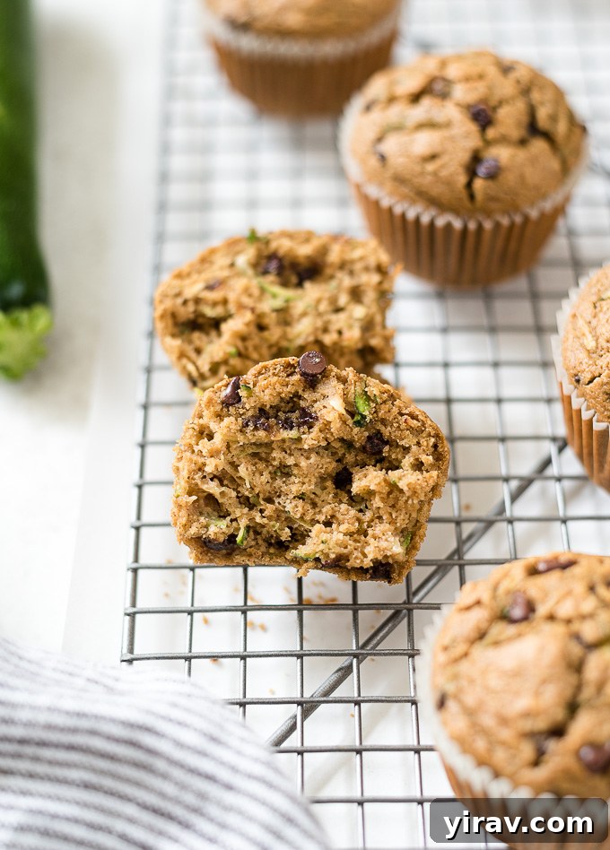 Healthy zucchini muffin cut in half on wire rack