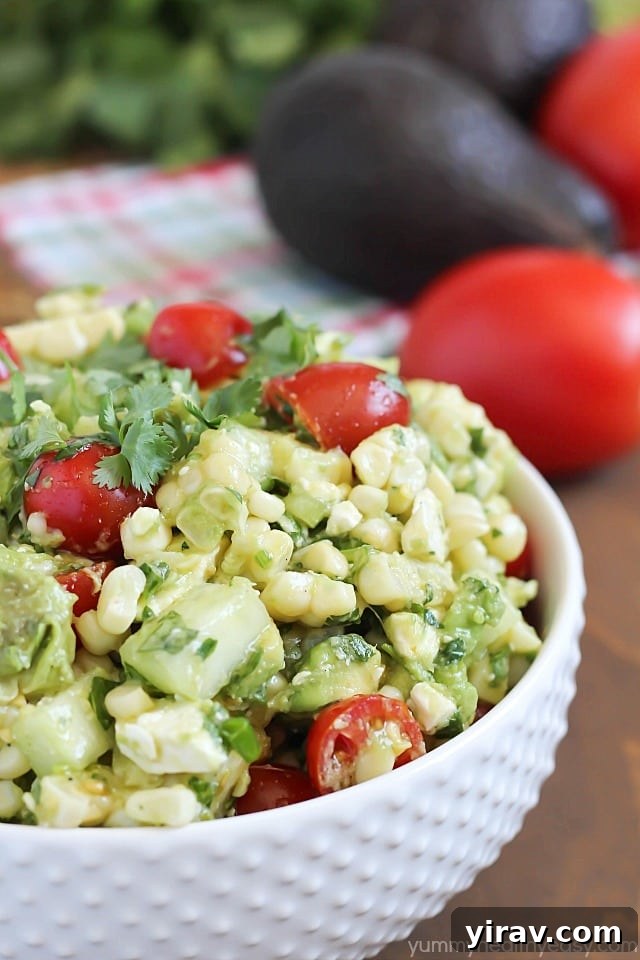 A vibrant bowl of Grilled Corn & Avocado Salad, featuring fresh corn, creamy avocado, and colorful vegetables.