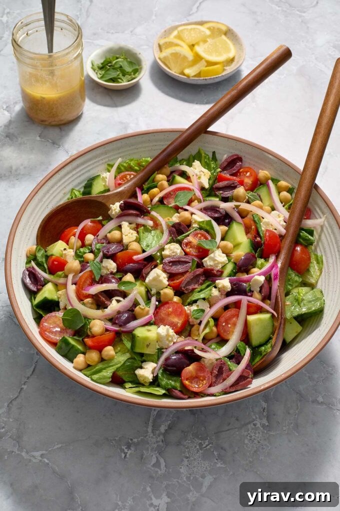 Vibrant Mediterranean Chop Salad 3 A large bowl of Mediterranean chopped salad with serving utensils, ready to be enjoyed.