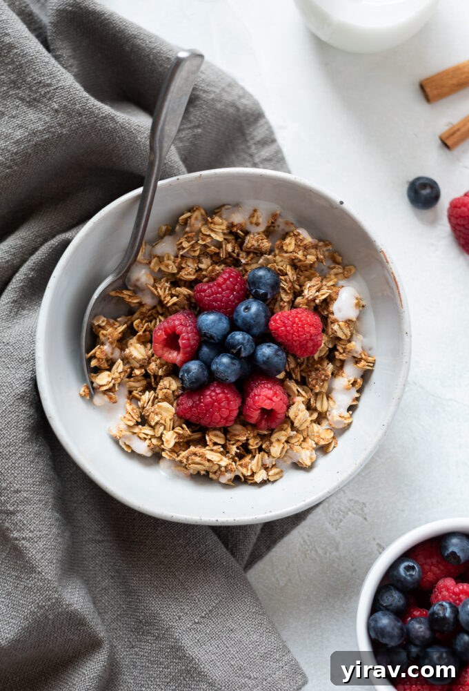 A close-up of almond butter granola in a bowl with milk, showcasing its texture.