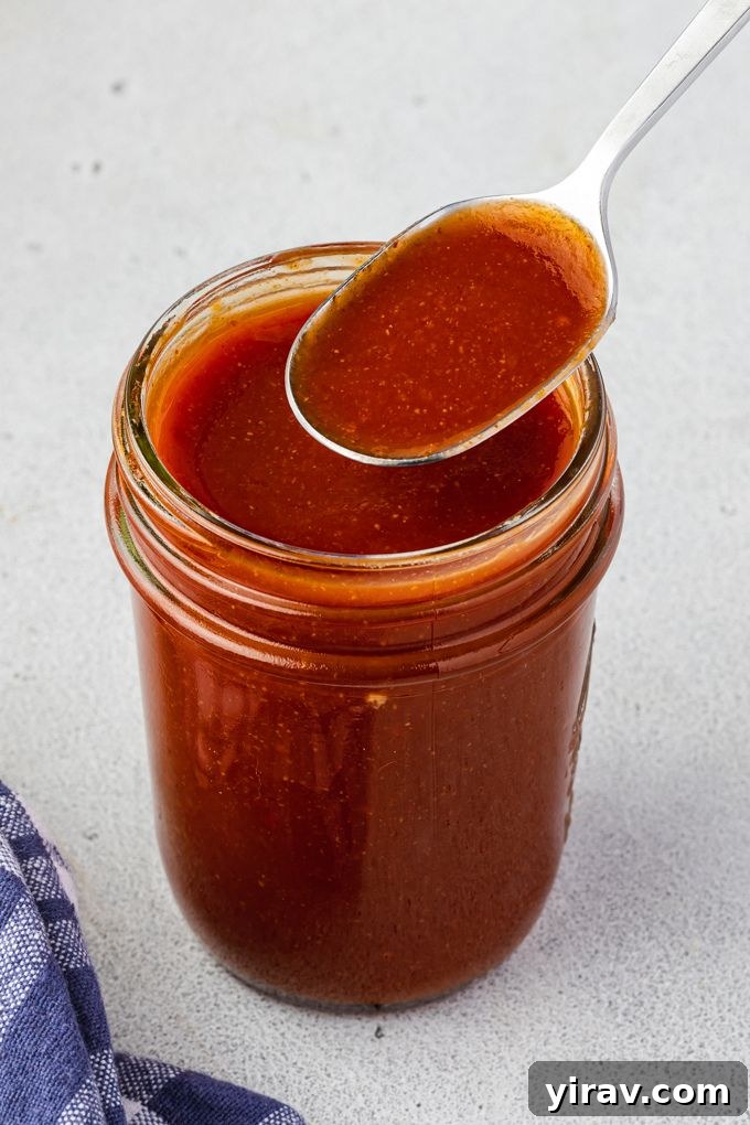 Crafted Bourbon BBQ Elixir 6 Bourbon barbecue sauce in a jar with a spoon
