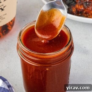 Spoon drizzling bourbon bbq sauce into a jar