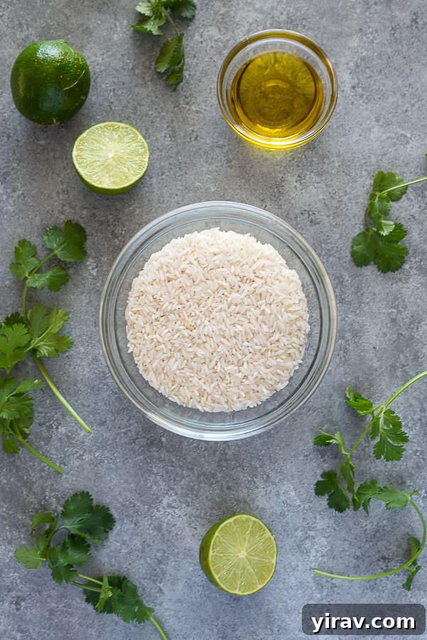 An assortment of fresh ingredients laid out for cilantro lime rice, including long grain white rice, fresh limes, a bunch of cilantro, and a bottle of olive oil.