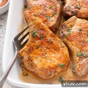 Tender Oven Baked Pork Chops 11 Oven baked pork chops in baking dish with serving fork.