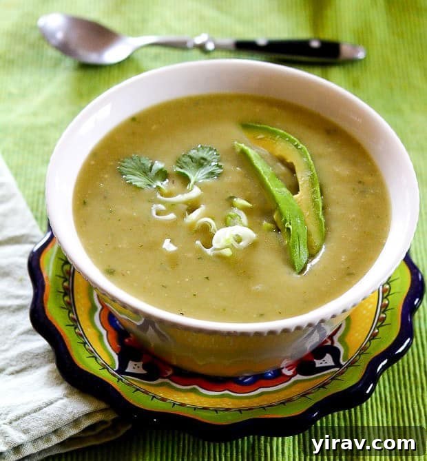 A refreshing bowl of verdant Chayote Chile Soup garnished with fresh avocado slices.