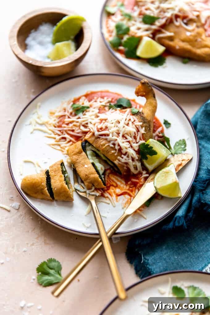 Perfectly fried Chile Rellenos served on a white plate with a fork and knife, showcasing their golden batter.