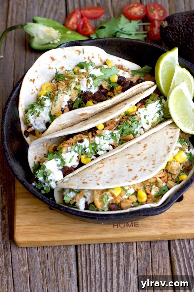 Delicious Vegetarian Black Bean Tacos filled with corn, poblano peppers, crumbled queso fresco, and a drizzle of cilantro crema.