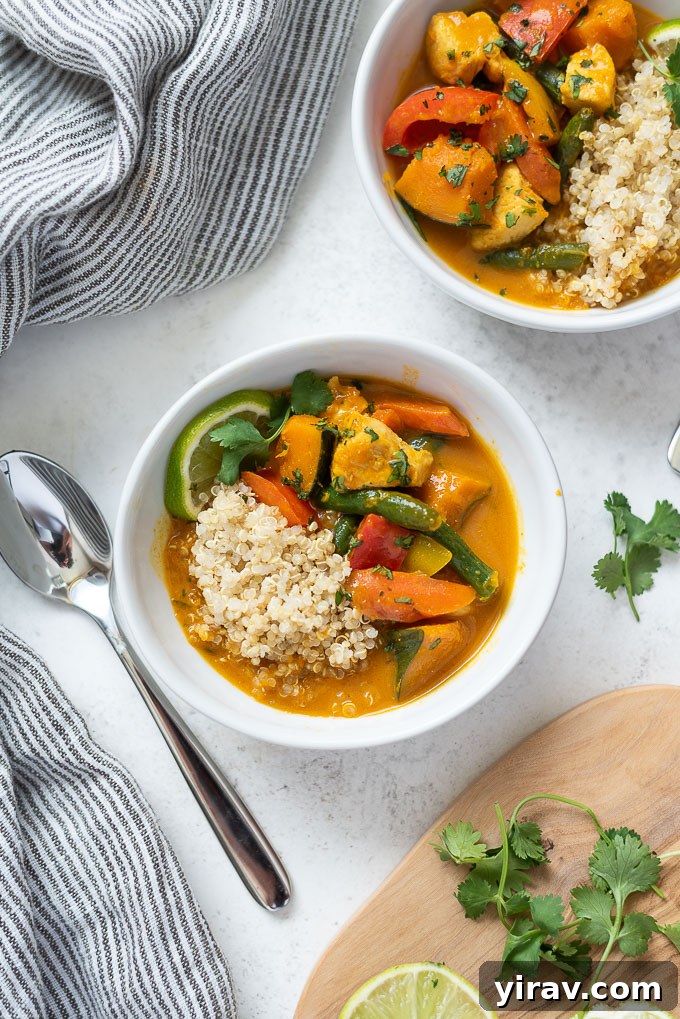 Creamy Thai Pumpkin Chicken Curry 3 Close-up of a serving of Thai pumpkin curry over quinoa in a white bowl.