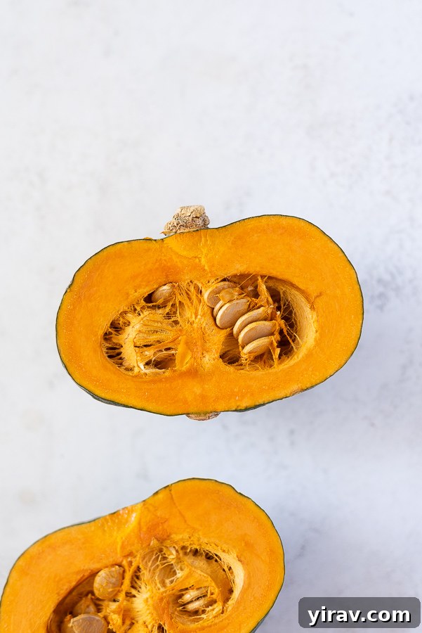 Creamy Thai Pumpkin Chicken Curry 7 A halved kabocha squash showing its vibrant orange flesh and green skin.