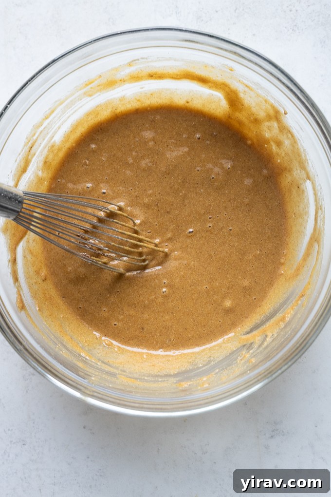 Pumpkin Spice Sunrise Bites 4 Whisked wet ingredients for pumpkin breakfast cookies in a large mixing bowl.