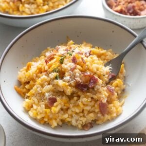 Pumpkin risotto in a bowl with fork digging in.