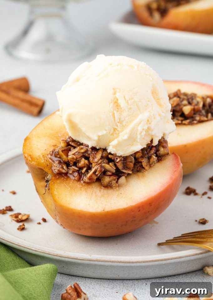 Baked Apple Bliss 2 Baked apples cut on a plate with ice cream, showcasing the delicious filling and tender texture.