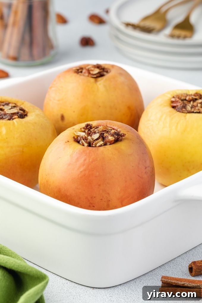 Baked Apple Bliss 6 A baking dish filled with four golden-brown baked apples, ready to be removed from the oven and served.