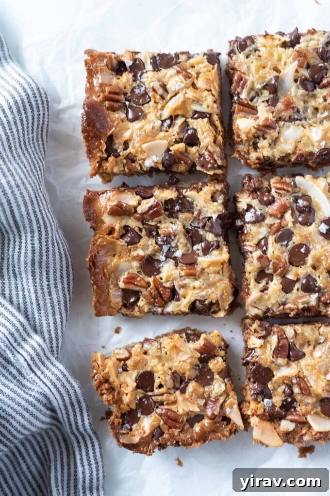 Magic cookie bars cut into squares, showcasing distinct layers.