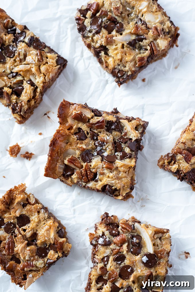 Seven layer magic cookie bars on parchment paper, ready to be served.
