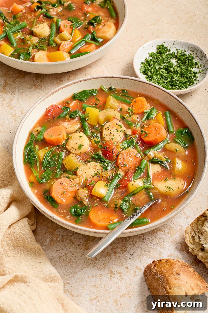 A close-up of a bowl of Instant Pot Vegetable Soup, garnished with fresh parsley and a spoon.