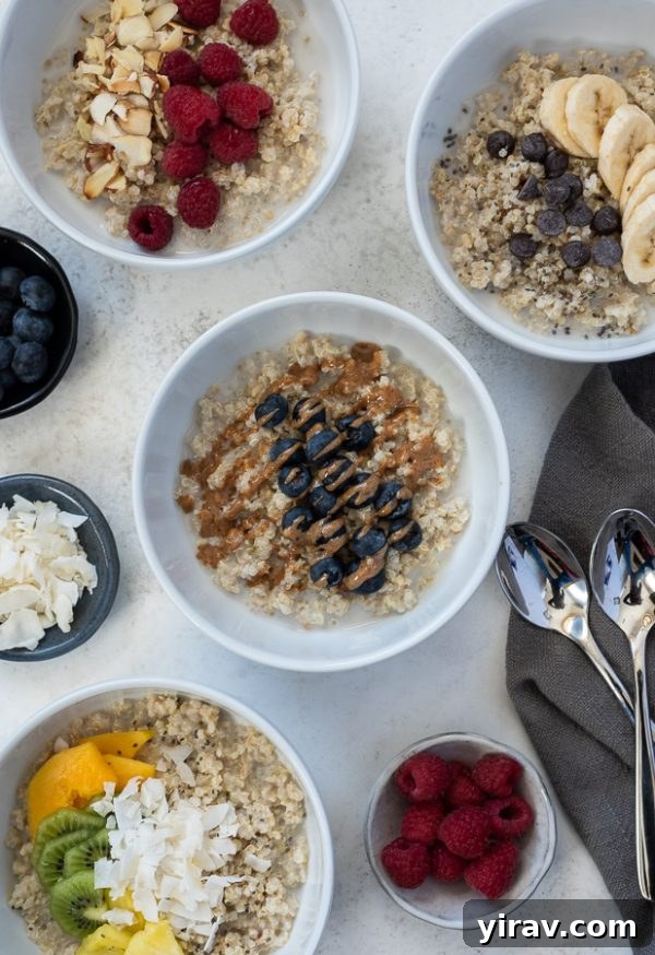 Overhead view of four different quinoa oatmeal breakfast bowls, showcasing diverse toppings like berries, tropical fruit, chocolate chips, and raspberries.