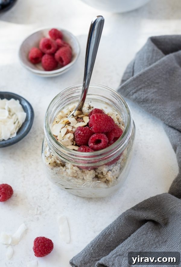 Vanilla almond raspberry quinoa oatmeal breakfast bowl in a meal prep jar, ready for an easy breakfast.