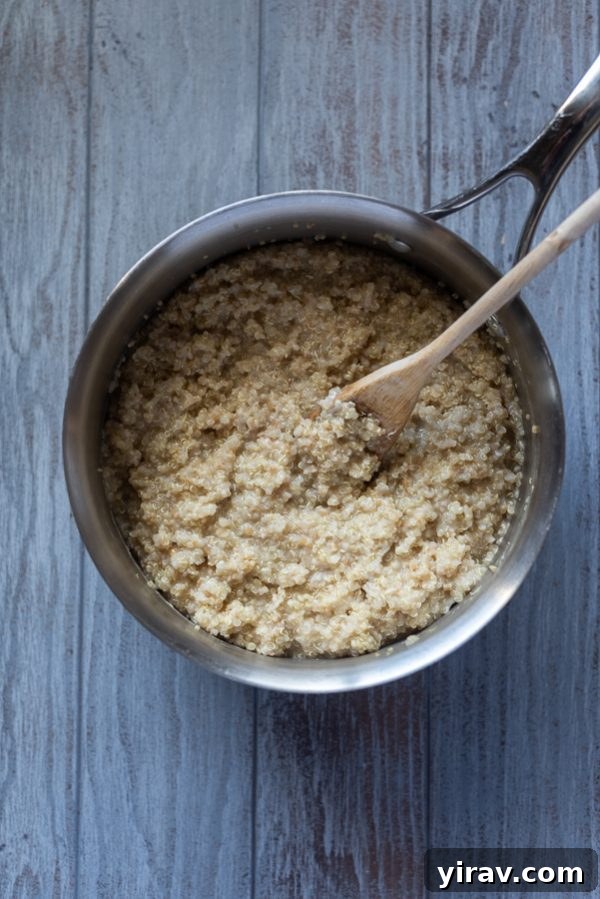 Quinoa oatmeal simmering in a pot on the stove, showing its creamy texture as it cooks.