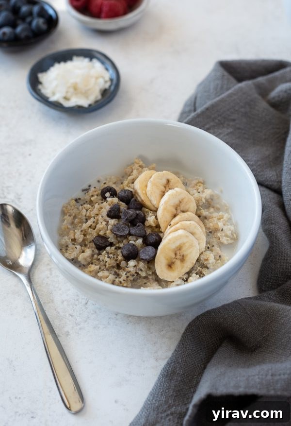 Front shot of a banana chocolate chip quinoa oatmeal breakfast bowl, with melted chocolate chips cascading over banana slices.