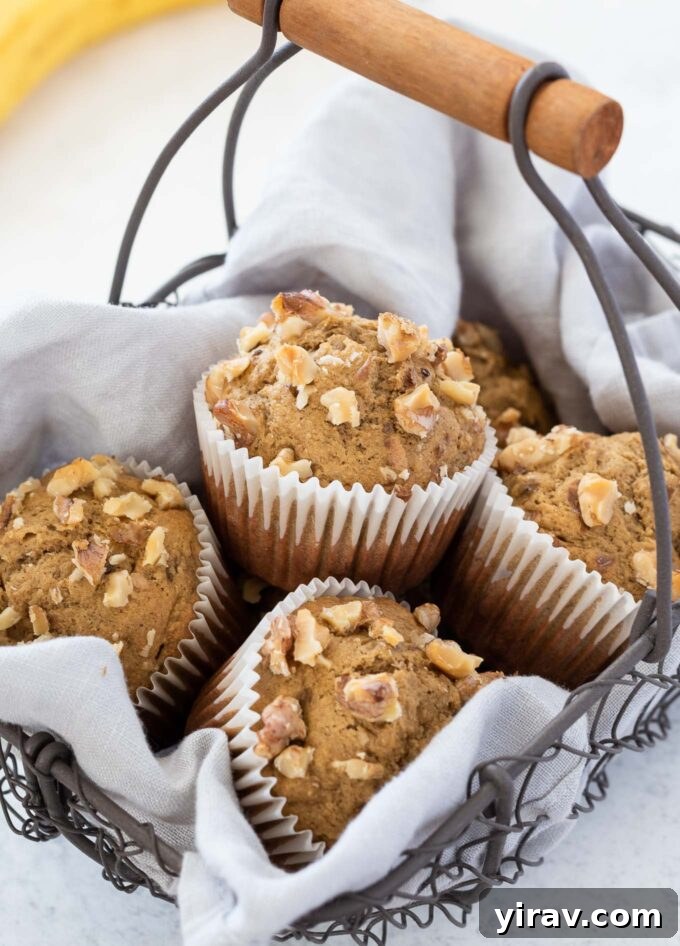 A basket overflowing with freshly baked, healthy banana oatmeal muffins, golden brown and inviting.